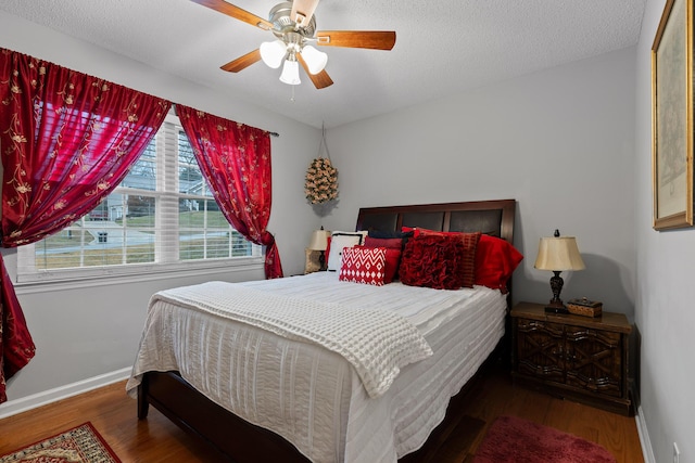 bedroom featuring ceiling fan, hardwood / wood-style floors, and a textured ceiling