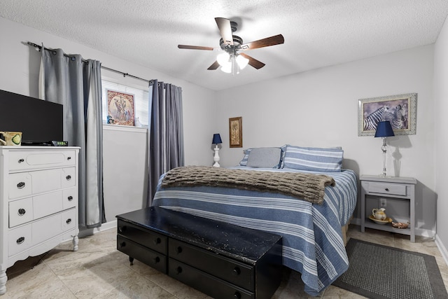 bedroom with ceiling fan and a textured ceiling