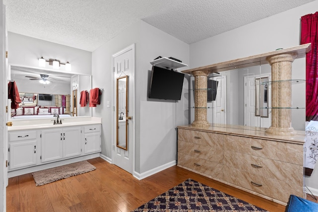 bathroom with vanity, ceiling fan, hardwood / wood-style flooring, and a textured ceiling