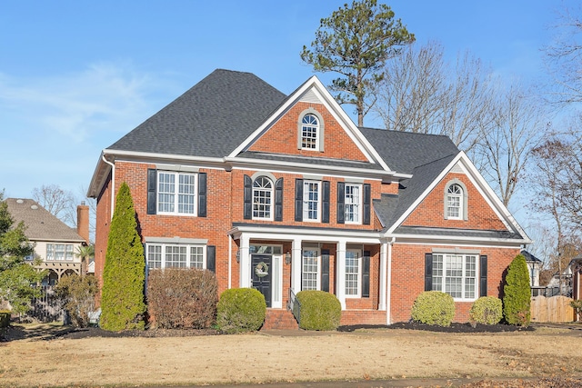 colonial inspired home featuring a front lawn