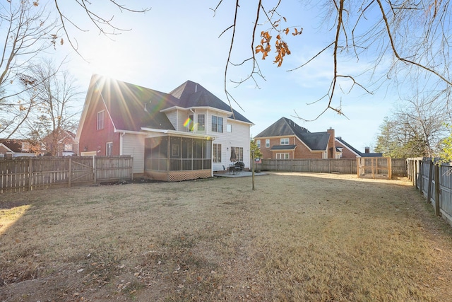 back of property with a sunroom and a lawn