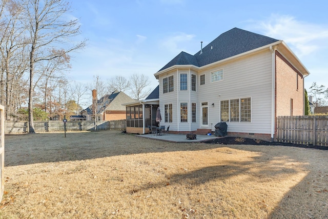 back of property with a lawn, a sunroom, and a patio