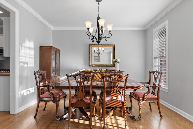 dining area featuring ornamental molding, a chandelier, and light hardwood / wood-style flooring