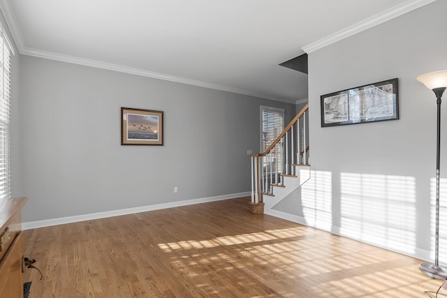 empty room with hardwood / wood-style flooring, ornamental molding, and a wealth of natural light