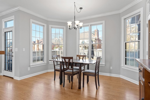 dining room featuring a notable chandelier, ornamental molding, and light wood-type flooring