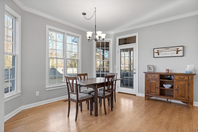 dining space with an inviting chandelier, ornamental molding, and light hardwood / wood-style floors