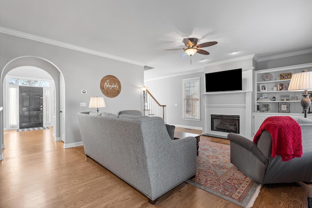 living room with ceiling fan, crown molding, light hardwood / wood-style flooring, and a healthy amount of sunlight