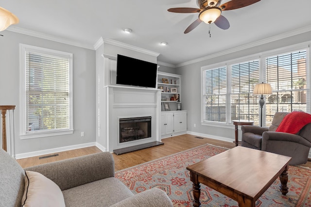 living room featuring crown molding, ceiling fan, and light hardwood / wood-style flooring