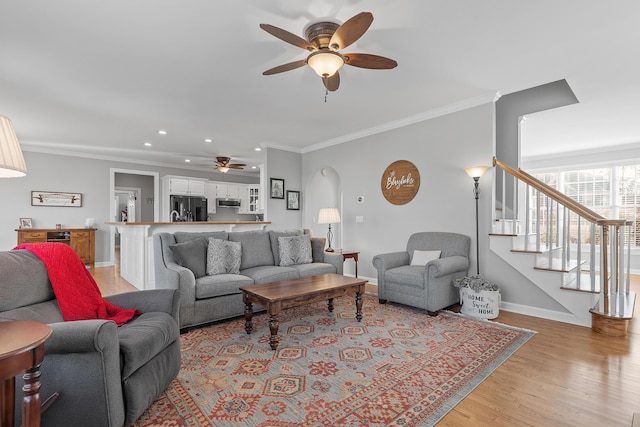 living room featuring crown molding, ceiling fan, and light hardwood / wood-style floors