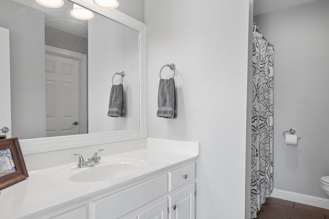 bathroom with vanity, wood-type flooring, and toilet