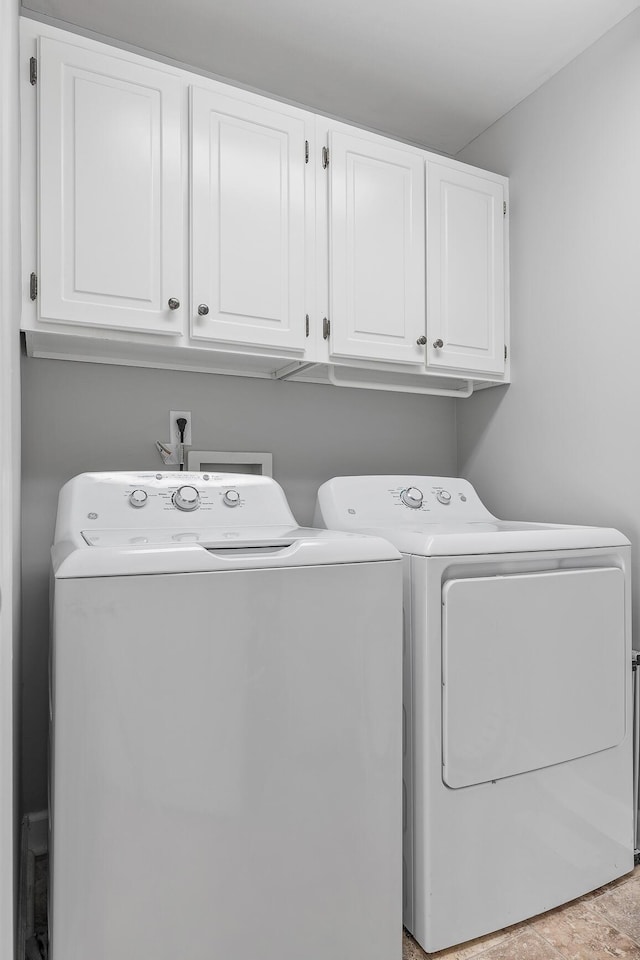 washroom featuring cabinets and washing machine and clothes dryer