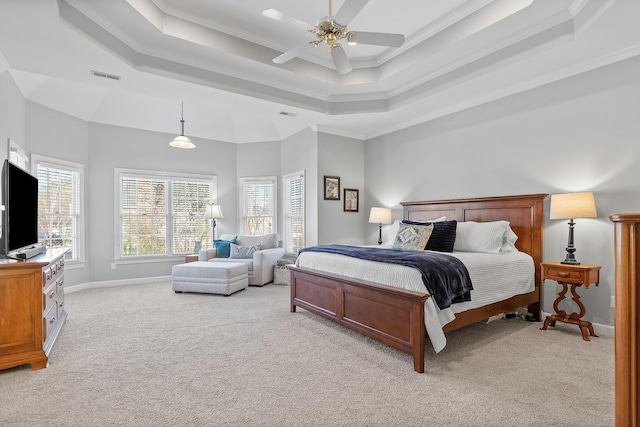 bedroom featuring multiple windows, ornamental molding, light colored carpet, and a raised ceiling