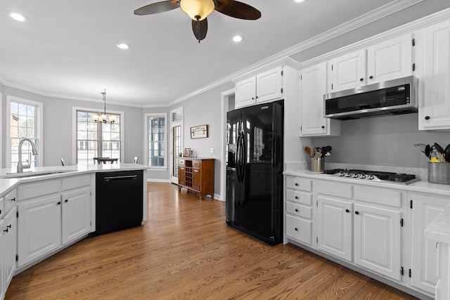 kitchen featuring sink, crown molding, black appliances, pendant lighting, and white cabinets