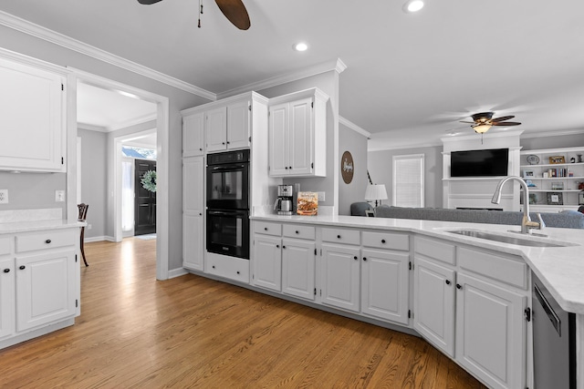 kitchen with sink, dishwasher, white cabinetry, black double oven, and ornamental molding