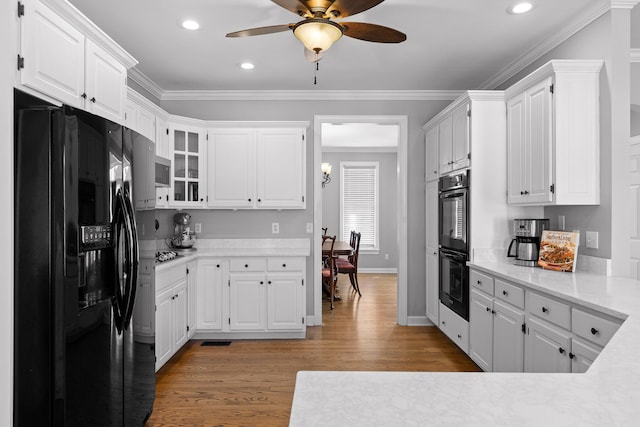 kitchen with white cabinetry, hardwood / wood-style flooring, ceiling fan, black appliances, and crown molding