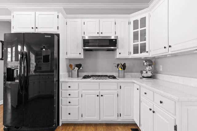 kitchen featuring appliances with stainless steel finishes, white cabinets, and light wood-type flooring