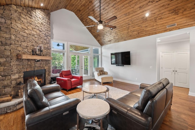 living room featuring wood ceiling, high vaulted ceiling, a fireplace, and hardwood / wood-style floors