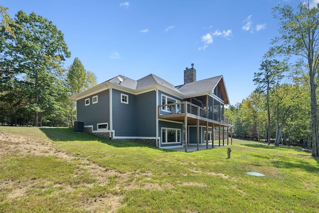 back of house with a deck, a patio area, and a lawn