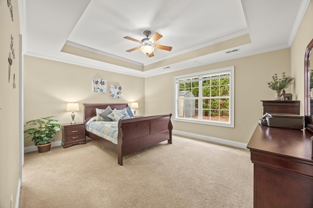 bedroom featuring ornamental molding, light carpet, ceiling fan, and a tray ceiling