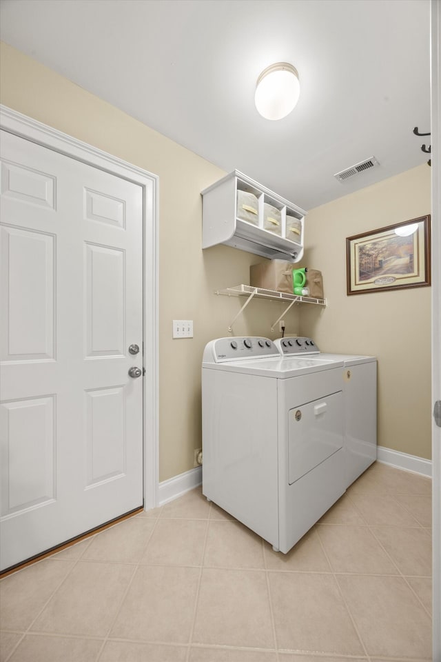 washroom with light tile patterned floors and washing machine and clothes dryer