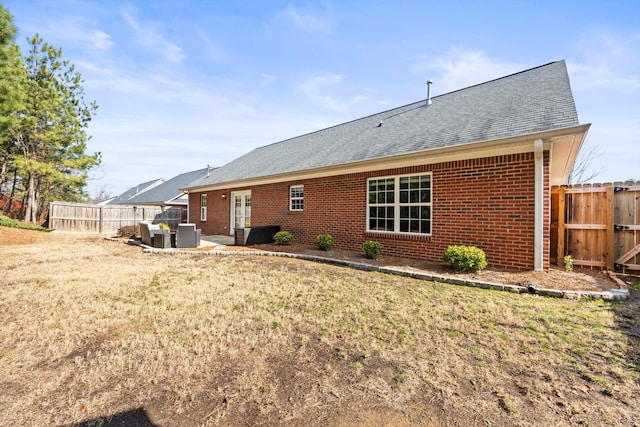 back of property with a yard and a patio