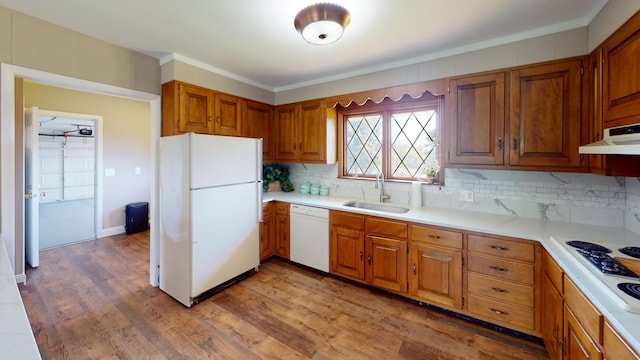 kitchen featuring extractor fan, sink, white appliances, light hardwood / wood-style floors, and decorative backsplash