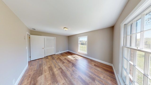 unfurnished bedroom featuring wood-type flooring and a closet