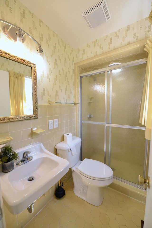 bathroom featuring tile walls, sink, toilet, and walk in shower