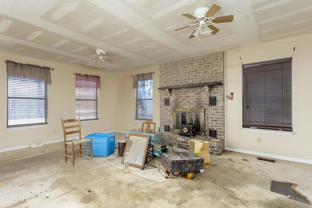 living room with ceiling fan and a wood stove