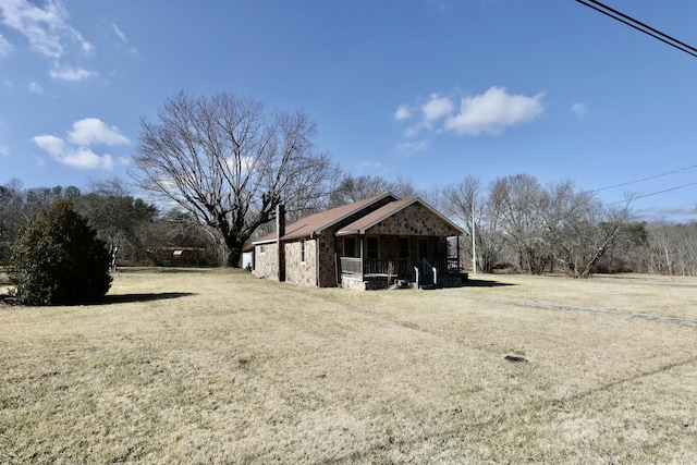 view of outdoor structure with covered porch and a lawn