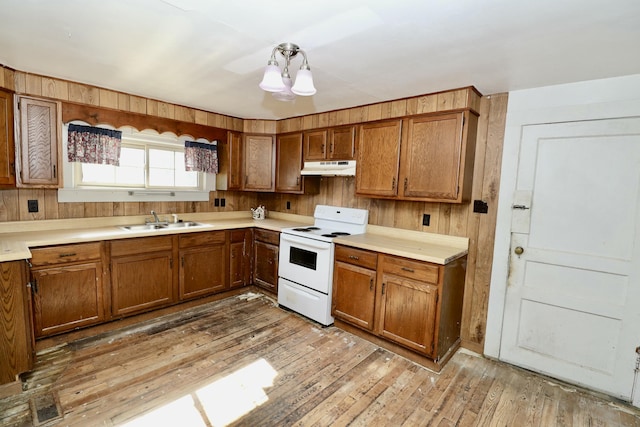 kitchen with sink, wooden walls, white electric stove, and light wood-type flooring