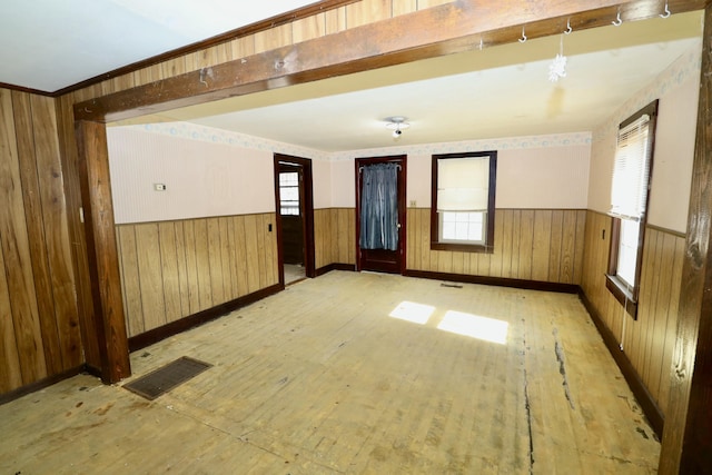 unfurnished room with wooden walls and light hardwood / wood-style floors