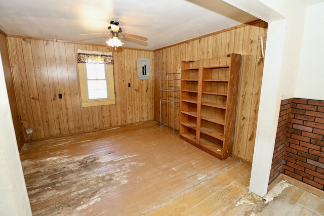 interior space featuring light hardwood / wood-style flooring, ceiling fan, and wood walls