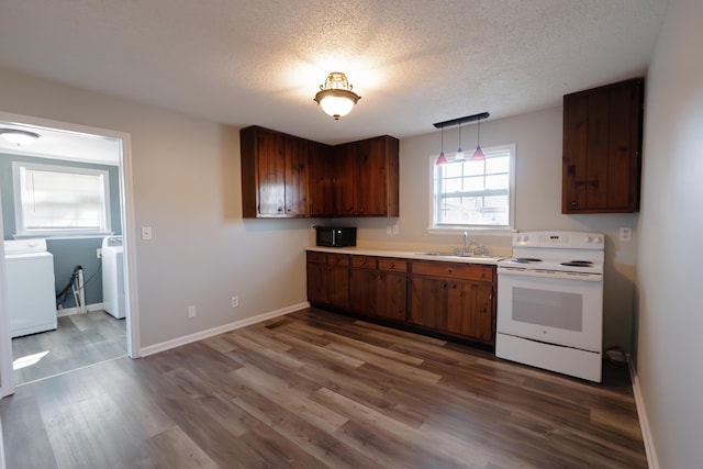 kitchen with sink, hanging light fixtures, hardwood / wood-style flooring, electric range, and washer and clothes dryer