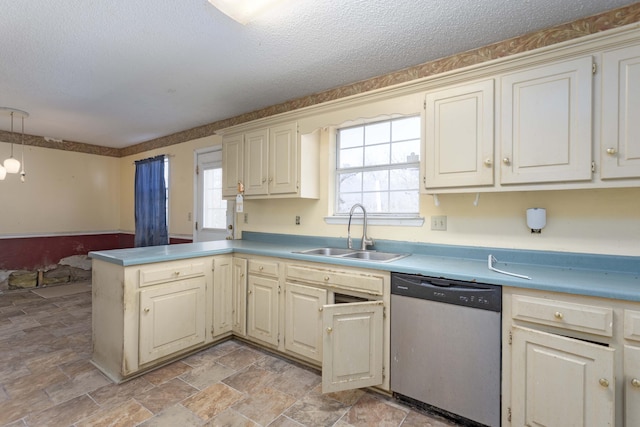 kitchen featuring pendant lighting, sink, dishwasher, a textured ceiling, and kitchen peninsula