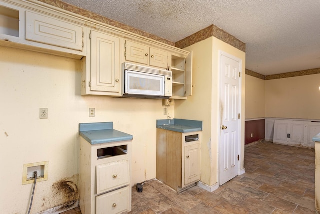 kitchen featuring cream cabinets and a textured ceiling