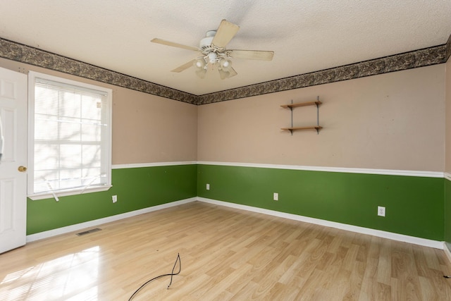 spare room with ceiling fan, wood-type flooring, and a textured ceiling