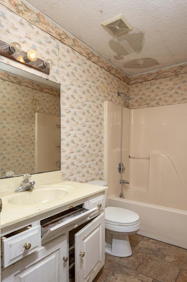 full bathroom featuring vanity, bathtub / shower combination, toilet, and a textured ceiling