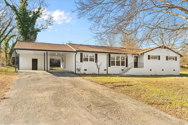 ranch-style house featuring a carport and a front lawn