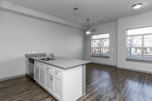 kitchen featuring sink, white cabinets, dark hardwood / wood-style flooring, stainless steel dishwasher, and light stone counters