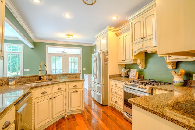 kitchen with stone countertops, sink, crown molding, and appliances with stainless steel finishes