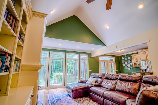 living room with high vaulted ceiling, a wealth of natural light, ornamental molding, and french doors