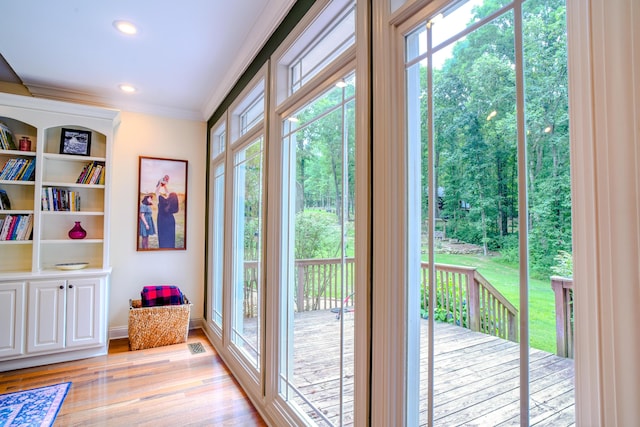 doorway to outside with crown molding and light hardwood / wood-style floors