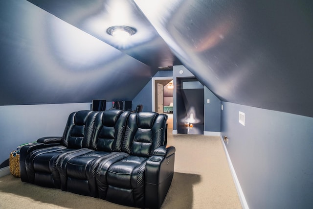 home theater room with lofted ceiling and carpet