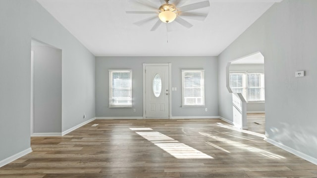 foyer with lofted ceiling, ceiling fan, wood-type flooring, and a healthy amount of sunlight