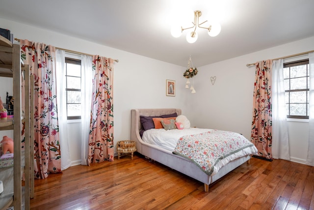 bedroom featuring hardwood / wood-style floors and a chandelier