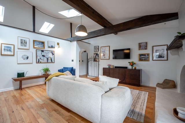 living room with lofted ceiling with skylight and light wood-type flooring