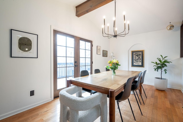 dining area featuring french doors, vaulted ceiling with beams, a notable chandelier, and light wood-type flooring