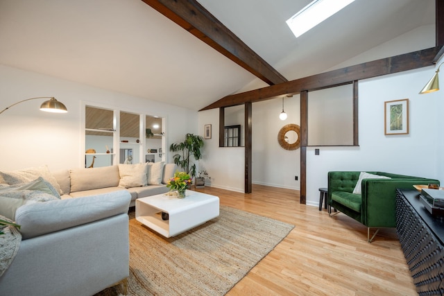 living room with vaulted ceiling with skylight and light hardwood / wood-style floors