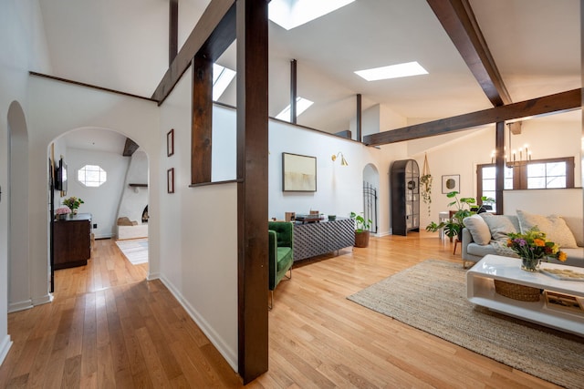 hallway featuring an inviting chandelier, hardwood / wood-style floors, beam ceiling, and high vaulted ceiling